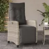 A rattan armchair with cushions on a tiled patio next to a small table with a cup. Podgląd zdjęcia produktu