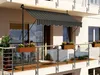 A balcony with a striped awning and flower boxes. Náhľad obrázku produktu