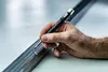 A hand is using a marker to draw a line on a metal bar. Anteprima dell’immagine prodotto