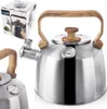 A stainless steel kettle with a wooden handle and lid, and a thermometer, is shown. A box for the kettle is also visible. Voir les images du produit