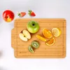 A collection of fruits, including apples, strawberries, oranges, lemons, and kiwis, are arranged on a wooden cutting board. Produktbild-Vorschau