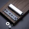 A magnetic door catch and its mounting plate are shown on a wooden surface. Produktbild-Vorschau