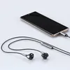 A pair of black and silver in-ear headphones connected to a smartphone via a USB-C port. Produktbild-Vorschau