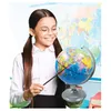 A young girl wearing glasses and a white shirt is pointing at a globe with a stick, in front of a world map. Náhľad obrázku produktu
