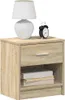 A wooden nightstand with a drawer and an open shelf, topped with a white lamp and a black alarm clock. Náhľad obrázku produktu