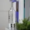 A clear glass bottle is being filled with water from a dispenser. Produktbild-Vorschau