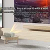 A projector is set up on a coffee table in a living room, projecting an image onto a wall. Náhled obrázku produktu