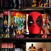 A shelf filled with Marvel action figures and comic books, with a prominent Deadpool mask in the center. Anteprima dell’immagine prodotto