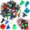 A large collection of assorted automotive clips and fasteners are displayed on a white background, with a hand holding a smaller selection of clips in the foreground. Podgląd zdjęcia produktu