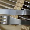 A close-up view of a set of steak knives and forks, with wooden handles, arranged in a wooden box. Produktbild-Vorschau