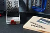 A set of drill bits in a case and two drill bits on a piece of wood, with a clamp in the background. Voir les images du produit