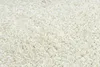 A close-up view of a shaggy cream-colored rug. Podgląd zdjęcia produktu