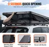 A person is opening a rooftop tent on a car. Produktbild-Vorschau
