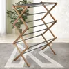 A wooden folding drying rack is shown in a room with a plant and a rug. Anteprima dell’immagine prodotto