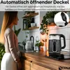 A woman in a kitchen is looking at a kettle on a countertop. The kettle is black and clear glass, with a digital display. Produktbild-Vorschau
