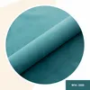 A close-up shot of rolled-up teal fabric inside a circle on a light peach and white background. Anteprima dell’immagine prodotto