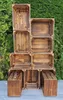 A stack of wooden crates arranged in a tiered display against a green leafy background. Náhled obrázku produktu