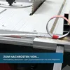 A close-up of a measuring tape being applied to a table saw or workbench. Náhled obrázku produktu