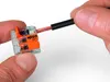 A hand is holding a WAGO 221-612 connector and inserting a wire into it. Podgląd zdjęcia produktu