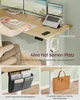 A person is using a standing desk with dual monitors, a laptop, and accessories. The image highlights the desk's features and organization capabilities. Produktbild-Vorschau