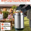 A family is gathered around a table in a backyard setting, with a large stock pot prominently displayed in the foreground. Voir les images du produit