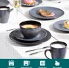 A table setting with plates, bowls, and mugs, some containing food and drink. Voir les images du produit
