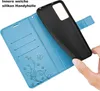 A hand is holding a black phone case over an open blue wallet-style phone case with card slots and a floral design. Produktbild-Vorschau