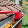 Cleaning out a gutter with a red scoop. Produktbild-Vorschau