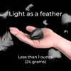 A hand holding a small black device with feathers floating around it, against a black background. Náhľad obrázku produktu