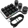 A close-up studio shot of a black and silver gaming keypad with three rotary knobs and a USB-C cable. Náhled obrázku produktu