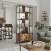A room divider shelf unit with storage cabinets is shown in a living room setting, next to a dining area and a sofa. Podgląd zdjęcia produktu