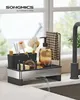 A kitchen sink organizer with various cleaning tools and soap dispenser, placed next to a faucet. Produktbild-Vorschau