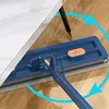Blauer Flachwischer mit grauem Mikrofasertuch reinigt unter einem weißen Tisch auf Holzboden Anteprima dell’immagine prodotto
