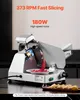 A commercial meat slicer is shown in operation, slicing a piece of meat. The background is a kitchen setting with a countertop. Náhled obrázku produktu