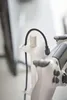 A close-up shot of a white controller holder with a black cable plugged into it. Produktbild-Vorschau