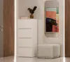 A white dresser with four drawers stands next to a mirror and a stool in a hallway. Náhľad obrázku produktu