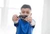 A young boy is holding a black panther toy in front of him. Produktbild-Vorschau