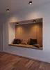 A built-in bench with cushions and wooden slat wall in a room. Produktbild-Vorschau
