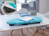 A table-top ironing board with clothes on it, placed on a table in a bright room with a window. Produktbild-Vorschau