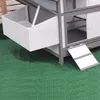 A close-up view of a white and gray chicken coop with a nesting box and a ramp, set on artificial grass. Podgląd zdjęcia produktu