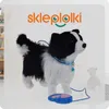 A toy dog with a leash and remote control on a light background, with a bookshelf and a teddy bear visible in the background. Anteprima dell’immagine prodotto