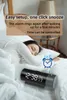 A person sleeping in bed next to a digital alarm clock. Podgląd zdjęcia produktu