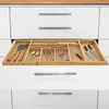 An open kitchen drawer with a bamboo cutlery organizer filled with various utensils. Podgląd zdjęcia produktu