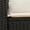 A close-up view of a black rattan sofa with white cushions. Produktbild-Vorschau