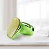 Two green hair removal devices are placed on a white surface next to a folded white towel. The background is blurred, suggesting an indoor setting with natural light. Produktbild-Vorschau