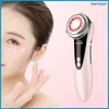 A woman's face with cream dots around her eye is shown next to a pink facial massage device. Náhľad obrázku produktu
