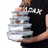A person is holding a stack of glass food storage containers. Anteprima dell’immagine prodotto