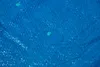 A close-up view of a blue tarp with water droplets on it. Produktbild-Vorschau