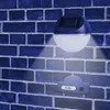 A solar-powered wall light mounted on a brick wall, illuminating a house number plate. Produktbild-Vorschau