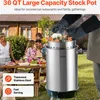 A family is gathered around a table outdoors, with a large stock pot in the foreground being used for cooking. Voir les images du produit